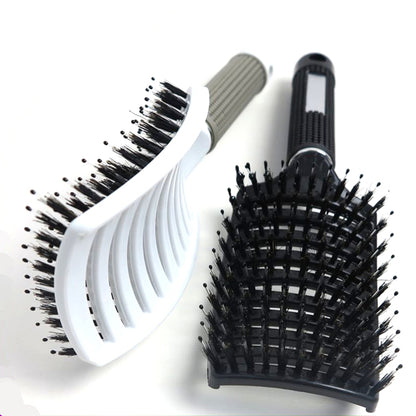 white Tiffany hair boar bristle brush on its side next to a black Tiffany boar bristle brush on its back